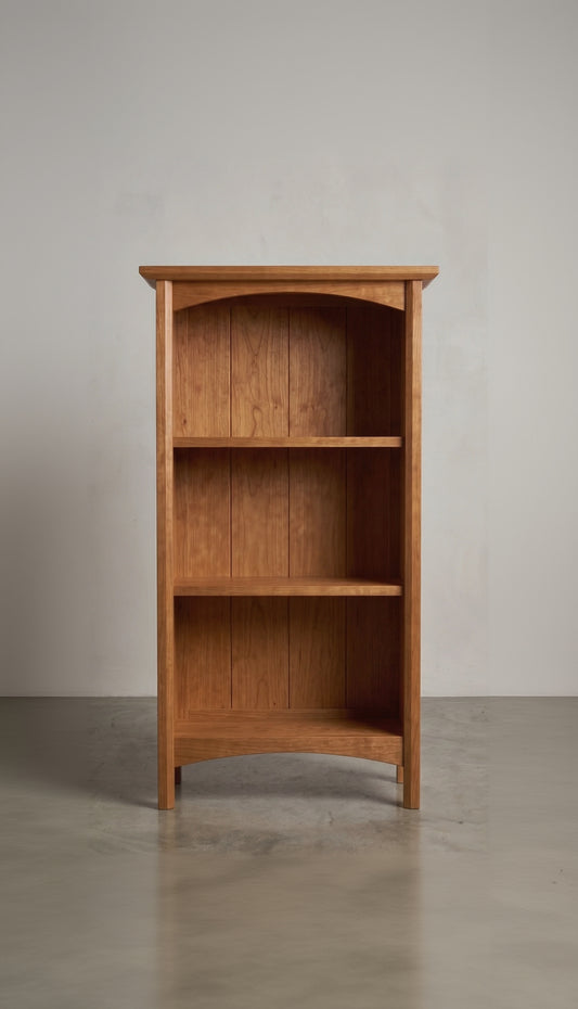 Wooden cherry bookshelf against a plain background
