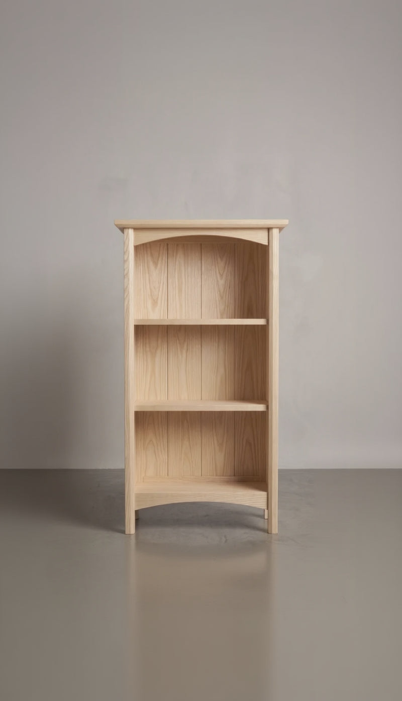 Wooden ash bookshelf with three shelves against a plain background