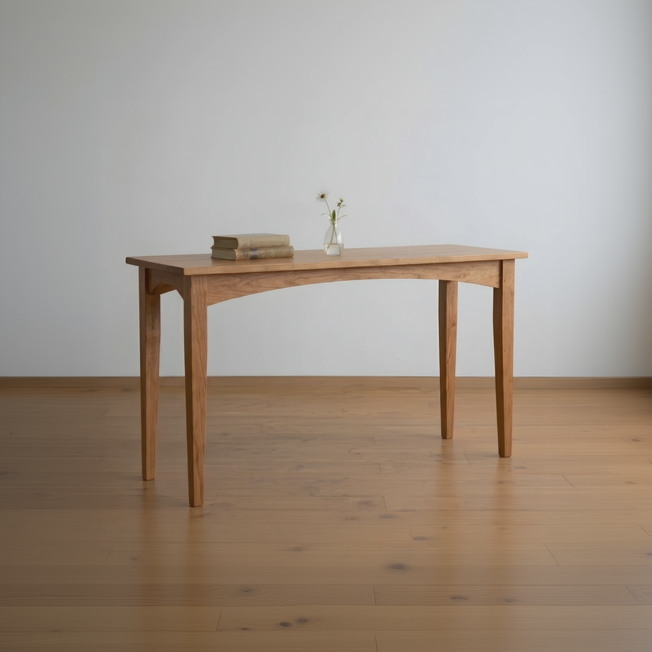 Wooden desk with a vase and books on a wooden floor against a white wall
