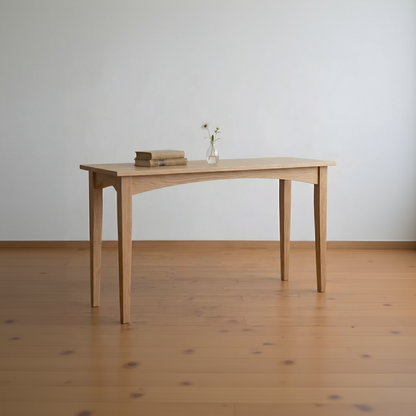 Wooden table with a vase and books on a wooden floor against a white wall